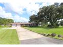 Ranch-style brick home with a large yard and mature oak tree at 5302 Turkey Creek Rd, Plant City, FL 33567