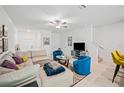 Open living room with sectional sofa, two armchairs and a large TV at 17399 Nectar Flume Dr, Land O Lakes, FL 34638