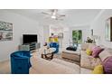 Open living room with sectional sofa, stylish decor, and a view into the kitchen at 17399 Nectar Flume Dr, Land O Lakes, FL 34638