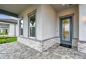 Inviting front entrance with stone accents, a glass-paneled door, and a gray-trimmed window at 1650 Fallon Pass, Zephyrhills, FL 33541