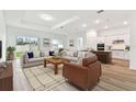 Bright, open-concept living room featuring hardwood floors and comfortable seating area at 1650 Fallon Pass, Zephyrhills, FL 33541