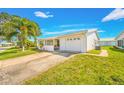 Front view of a white single-story home with a garage at 9125 39Th N Ln, Pinellas Park, FL 33782