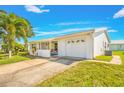 White single-story home with a garage and lush lawn at 9125 39Th N Ln, Pinellas Park, FL 33782