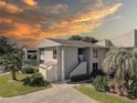 Exterior of a well-maintained condo with a private entrance and lush landscaping with a sunset background at 428 Windrush Bay Dr, Tarpon Springs, FL 34689