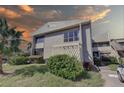 Exterior view of condo building at sunset, featuring landscaping and parking at 428 Windrush Bay Dr, Tarpon Springs, FL 34689