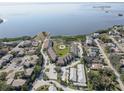 Aerial view of waterfront community with numerous buildings, parking, and a small pond at 428 Windrush Bay Dr, Tarpon Springs, FL 34689
