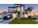 Luxury home with a two-car garage, modern design, and a well-kept lawn with high-end vehicles parked at 2832 W Vina Del Mar Blvd, St Pete Beach, FL 33706
