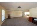 A spacious living room boasts neutral walls and plush carpeting at 12210 Buttonwood Row, Hudson, FL 34667