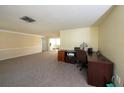 Inviting living room featuring plush carpeting, a large window, and adjacent sunroom at 12210 Buttonwood Row, Hudson, FL 34667
