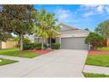 Charming single-story home with a well-manicured lawn, beautiful landscaping, and a two-car garage at 30735 Lanesborough Cir, Wesley Chapel, FL 33543