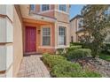 Front entrance with a red door and landscaping at 18051 Java Isle Dr, Tampa, FL 33647