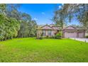 House with a large front yard, mature trees, and a three-car garage at 12532 River Birch Dr, Riverview, FL 33569