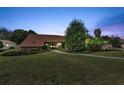 Evening view of a home with well-manicured lawn at 5375 Patricia Pl, Weeki Wachee, FL 34607