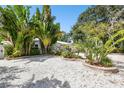 Single Gathering home featuring meticulous tropical landscaping with stone ground cover and a blue sky at 1906 2Nd St, Indian Rocks Beach, FL 33785