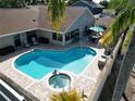 A refreshing swimming pool and hot tub combo surrounded by a brick-paved patio and lush greenery at 4608 Apple Ridge Ln, Tampa, FL 33624