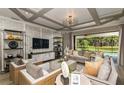 Open-concept living area with coffered ceiling, large windows, and access to the pool area at 11178 Manor House Ln, Odessa, FL 33556