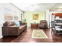 Living room with dark brown leather furniture, hardwood floors, and kitchen view at 1801 Bedford Ln # 27, Sun City Center, FL 33573