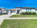 Modern single-Gathering home with gray double front doors and landscaping at 8731 Sanders Tree Loop, Wesley Chapel, FL 33545