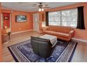 Living room features orange walls, wood-look floors, and a comfy seating area at 1949 Kings Hwy, Clearwater, FL 33755