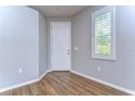 Bright entryway with hardwood floors, white door, and window with plantation shutters at 20920 Eustis Rd, Land O Lakes, FL 34637