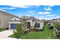 A well-manicured lawn compliments this single story home with blue shutters and a matching blue garage door at 5521 Limelight Dr, Apollo Beach, FL 33572