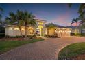 Charming home with manicured landscaping, brick driveway, and a three-car garage for ample parking at 7925 Royal Queensland Way, Lakewood Ranch, FL 34202