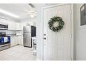 Bright kitchen entry with white cabinets, stainless steel appliances, and a decorative wreath at 12049 Hoosier Ct # 202, Hudson, FL 34667