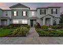 Charming townhome featuring a manicured lawn with lush landscaping, a walkway, and pleasant curb appeal at 14929 Promenade Pkwy, Odessa, FL 33556