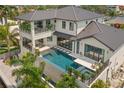 An eye-level exterior shot showcasing a modern pool with stepping stones and a spa attached to a two story home at 7949 2Nd S Ave, St Petersburg, FL 33707