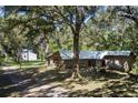 Property featuring a main house and a detached building, nestled among trees at 12247 Ponce De Leon Blvd, Brooksville, FL 34601