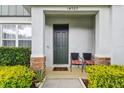 Townhome front entry with dark door, landscaping and walkway at 14929 Promenade Pkwy, Odessa, FL 33556