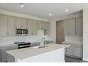 Modern kitchen with gray cabinets, white countertops, and stainless steel appliances at 10341 Fieldstone Myrtle Way, San Antonio, FL 33576