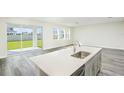 Modern kitchen with a large island, stainless steel sink, and white quartz countertops at 10341 Fieldstone Myrtle Way, San Antonio, FL 33576