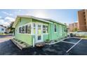 Quaint beach cottage with green exterior and private parking at 19718 Gulf Blvd, Indian Shores, FL 33785