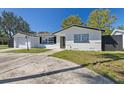 Recently remodeled home with white exterior and a large driveway at 10735 Gawain Rd, Port Richey, FL 34668