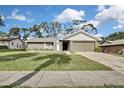 Single-story home with a two-car garage, neat landscaping, and a welcoming walkway at 3063 E Dorchester Dr, Palm Harbor, FL 34684