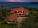 Beautiful home at dusk with clay tile roof, water views, and inviting curb appeal at 3418 Braeside Pl, Clearwater, FL 33759