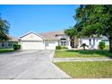 Two-story house with a three-car garage and landscaped yard at 13267 Linzia Ln, Spring Hill, FL 34609