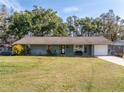 Ranch style home with green exterior and attached garage at 4744 School Rd, Land O Lakes, FL 34638