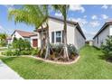 Well-maintained home with landscaping and palm trees at 5512 Little Path Dr, Wimauma, FL 33598