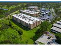 Aerial view of condo community showing building exteriors, landscaping, and parking at 1540 Glen Oaks E Dr # B134, Sarasota, FL 34232