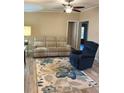 Inviting living room with wood-look flooring and a floral area rug creating a cozy atmosphere at 36822 Kay Ave, Zephyrhills, FL 33542