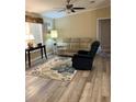 Inviting living room with wood-look flooring and a floral area rug creating a cozy atmosphere at 36822 Kay Ave, Zephyrhills, FL 33542