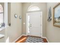 Bright entryway with hardwood floors, a white door, and nautical-themed decor at 12923 Carlington Ln, Riverview, FL 33579