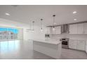 Bright, spacious kitchen features white cabinets, stainless steel appliances, large island, and opens to a living space at 920 N Osceola Ave # 401, Clearwater, FL 33755
