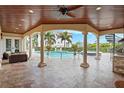 Resort-style pool and spa with covered patio, outdoor kitchen, and spiral staircase at 3341 Gulf Blvd, Belleair Beach, FL 33786
