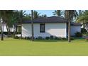 Rear view of a house showcasing a clean, white exterior and a spacious backyard at 4026 Yucatan Cir, Port Charlotte, FL 33948