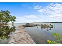 Waterfront home's wooden dock on a sunny day, offering serene water views and boat access at 168 Rue Des Chateaux, Tarpon Springs, FL 34688