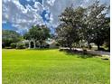 Beautiful home with a big yard and lovely landscaping, under a partly cloudy blue sky at 168 Rue Des Chateaux, Tarpon Springs, FL 34688