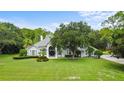 Charming single-story home with a manicured lawn and mature oak tree in the front yard at 168 Rue Des Chateaux, Tarpon Springs, FL 34688